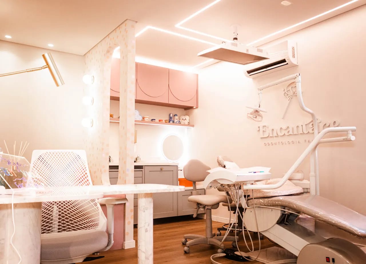 Visão geral de um consultório rosa da Encantare, no Bacacheri, com cadeira odontológica e iluminação suave