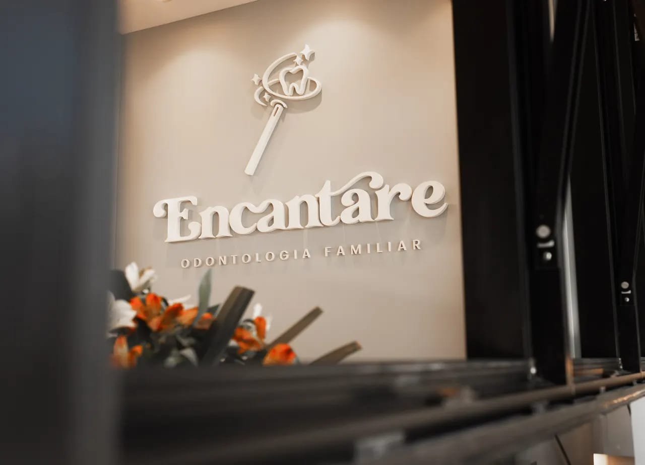 Logotipo da Encantare Odontologia Familiar na parede da recepção da clínica, no Bacacheri