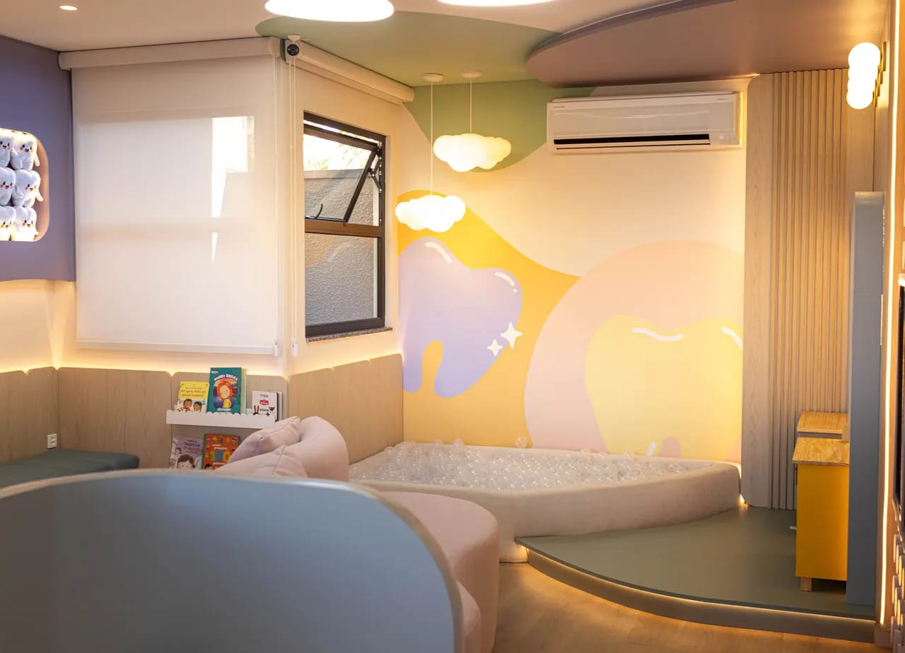 Sala de espera lúdica da Encantare com piscina de bolinhas, livros infantis e sofá